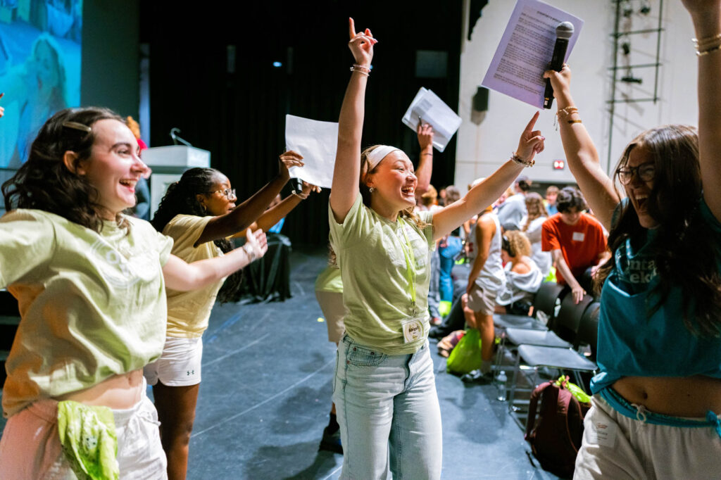 Muhlenberg College students in orientation T-shirts dance on a stage