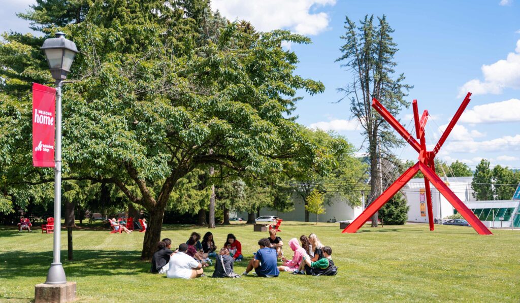 Soon-to-be college students sit in a circle on the college lawn on a sunny summer day