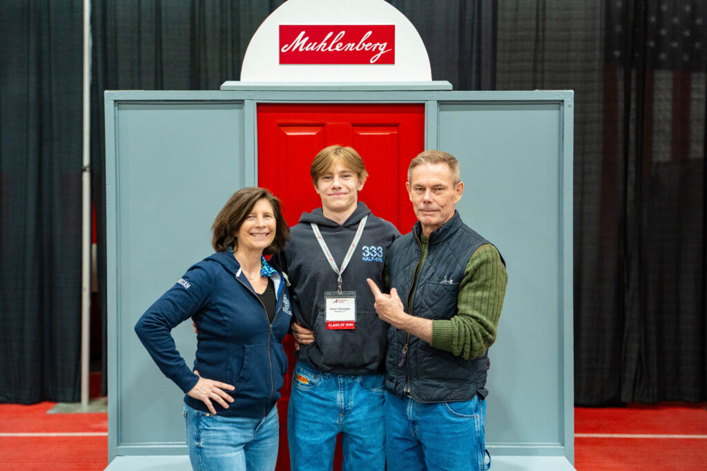 The family of a prospective Muhelenberg student pose for a photo in front of a set of red doors.