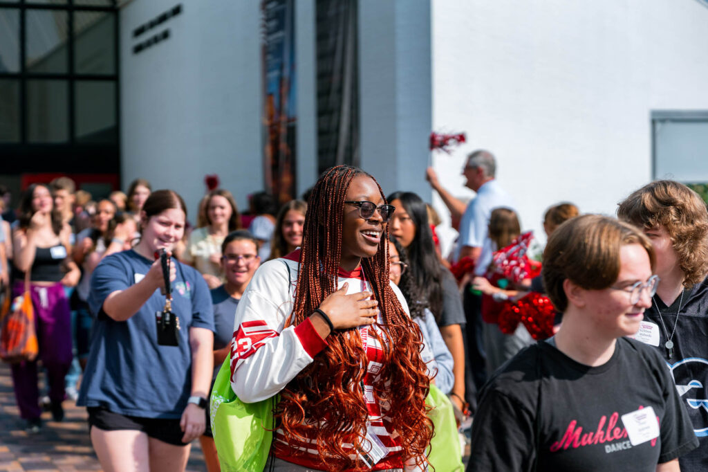 New Muhlenberg College students walk past cheering supporters during orientation