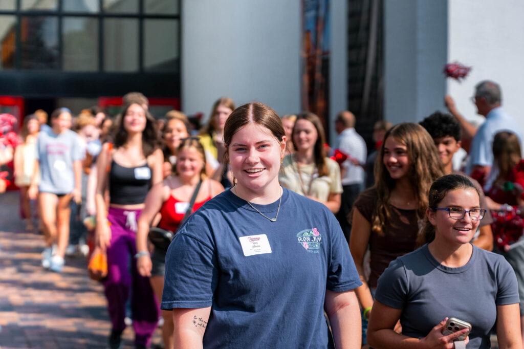 A new Muhlenberg College student in a blue shirt surrounded by other new students