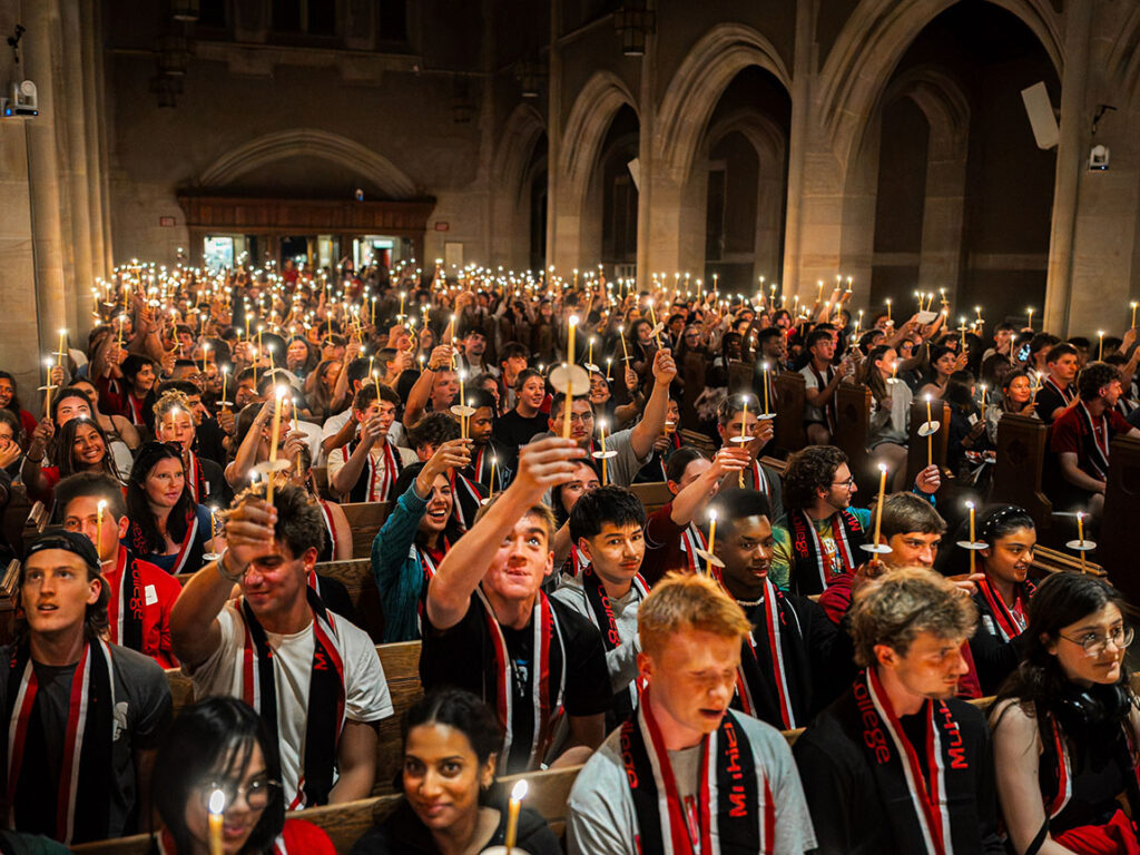 Students hold candles in the chapel