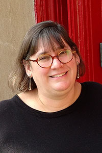 A headshot of a college professor wearing glasses