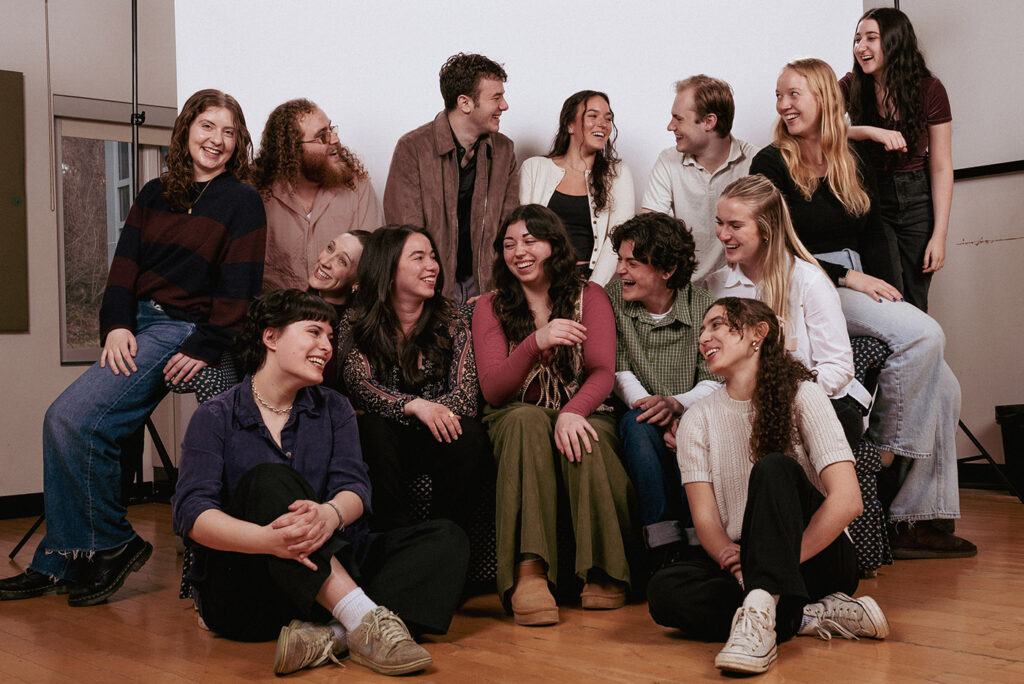 A group of 14 actors in their early 20s, posing for the camera.