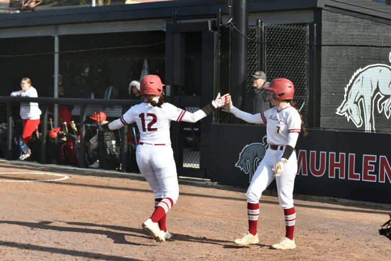 Mules softball players celebrate a run on the new on-campus field.