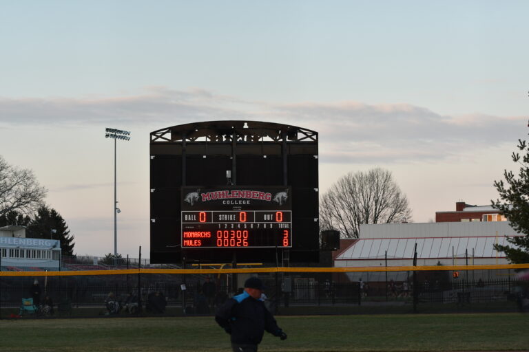 The Mules Softball scoreboard shows Mules 8, Monarchs 3 at sunset.