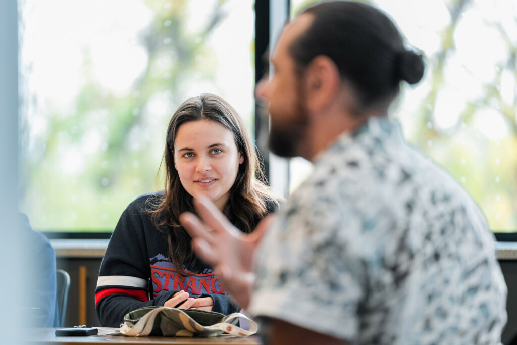 A college student looks at a college professor as he speaks during class